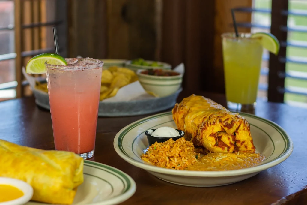 Tex-Mex meal with cheesy burritos, drinks, chips, and salsa.