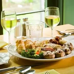 Appetizers, wine, and water on a dining table set for two.
