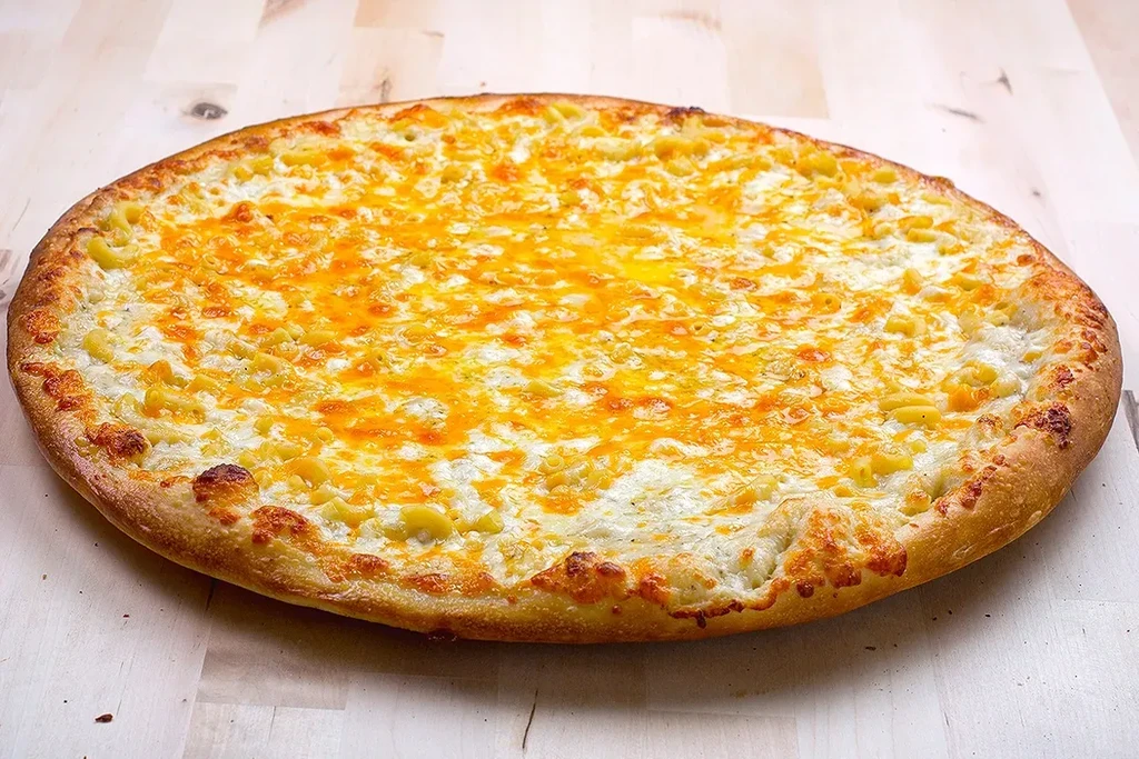 Whole round macaroni and cheese pizza, showing melted cheese and golden crust.