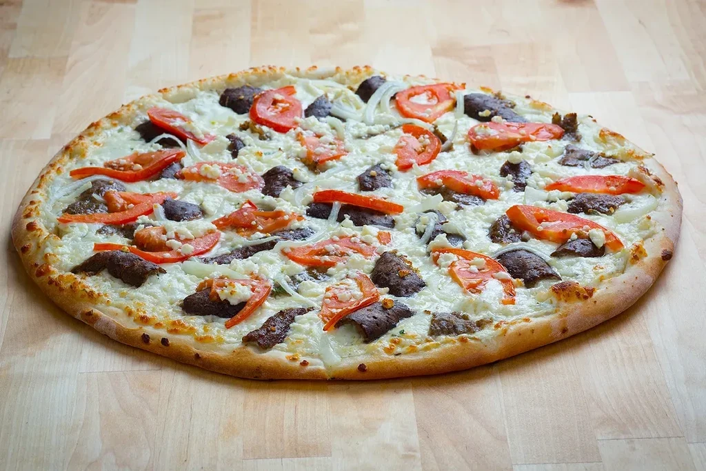 Freshly baked white sauce pizza with gyro, tomato, onion, and feta.