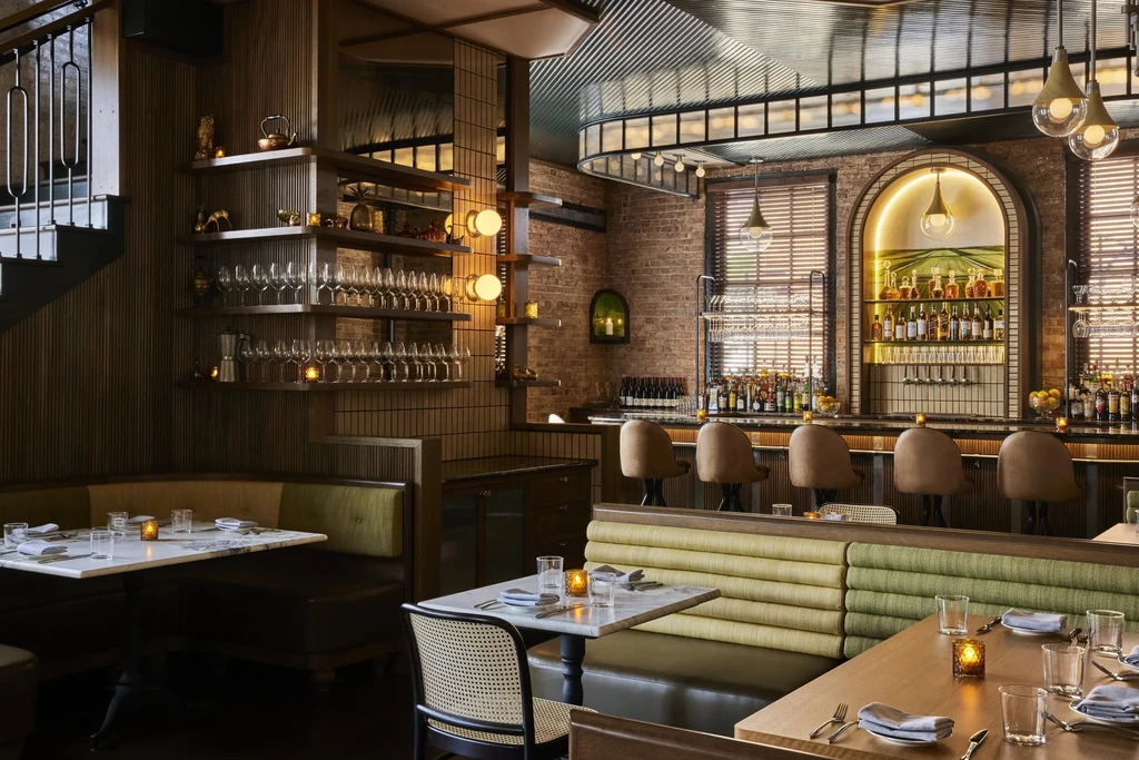 Warmly lit upscale restaurant interior with multiple dining areas and bar.