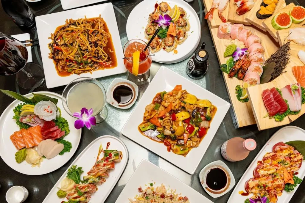 Abundant overhead spread of Japanese sushi and Chinese stir-fries.