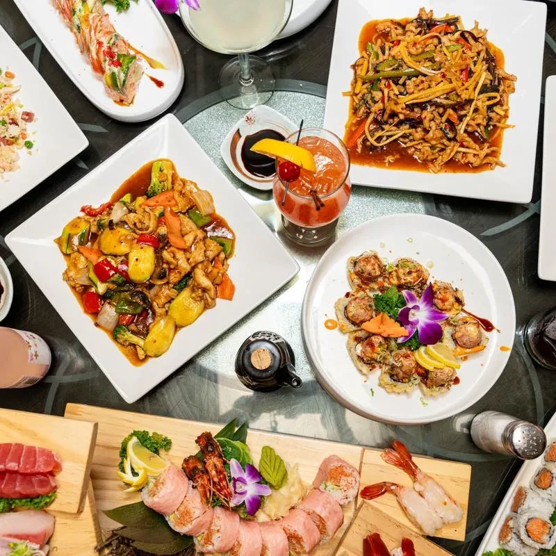 Overhead view of a table with diverse Asian dishes and drinks.