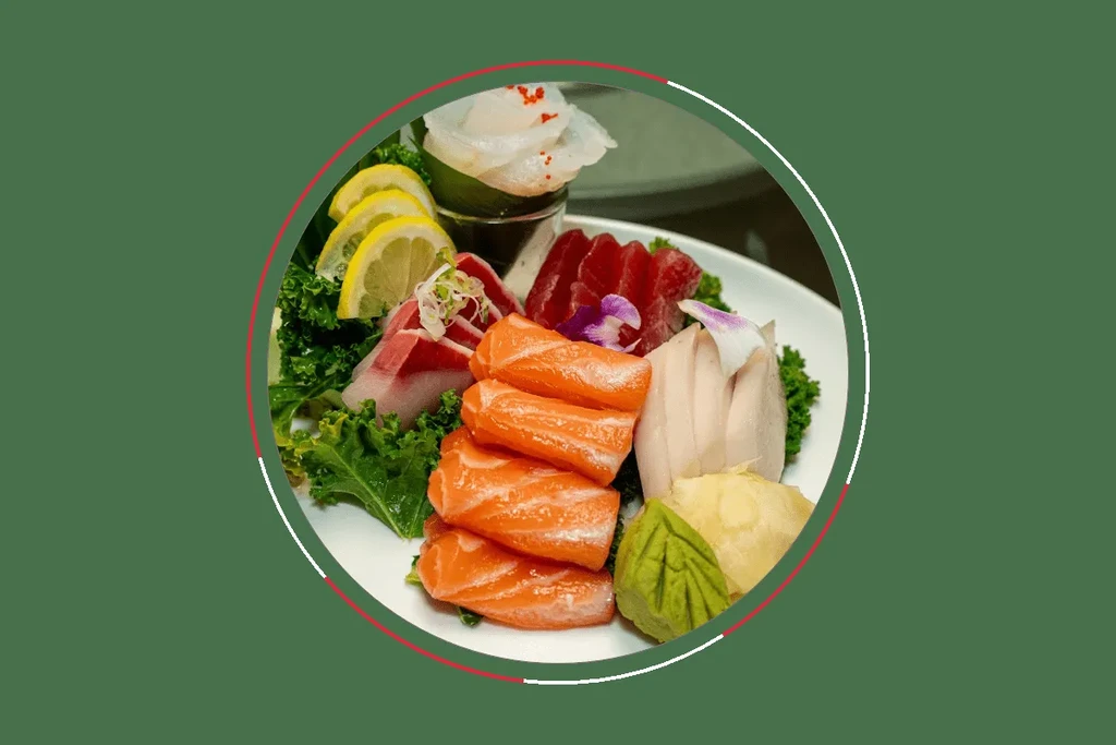 Sashimi plate with salmon, tuna, white fish, garnished with an orchid.