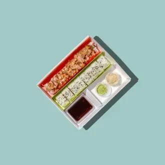 Sushi and condiments in white takeout container, top-down view.