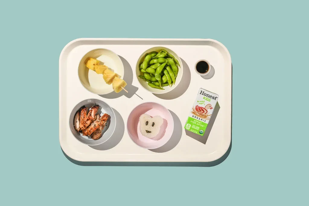 Children's meal: bear-shaped rice, chicken, edamame, pineapple, and apple juice.