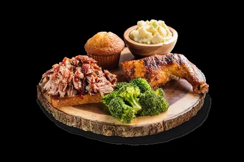 Rustic platter with pulled pork, muffin, mashed potatoes, grilled chicken, broccoli.