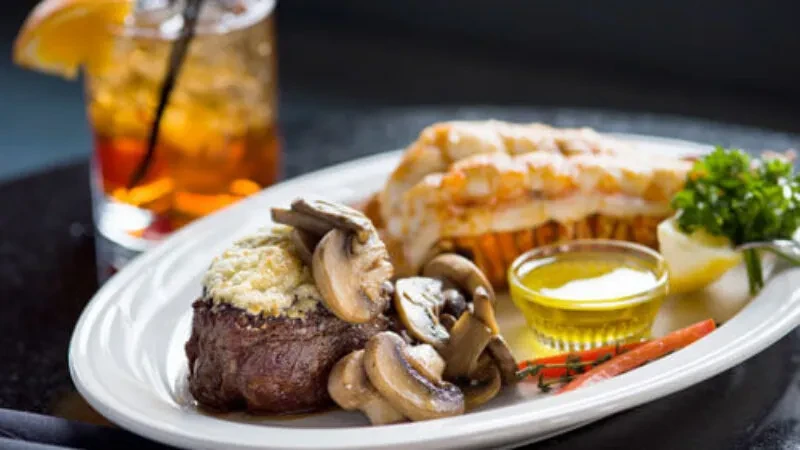 Thick-cut steak, broiled lobster tail, mushrooms, lemon, and butter sauce.