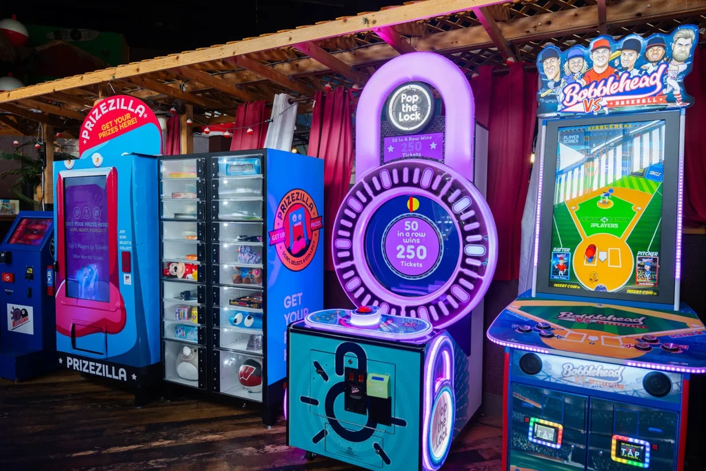 Brightly lit arcade and prize redemption machines in a rustic entertainment area.