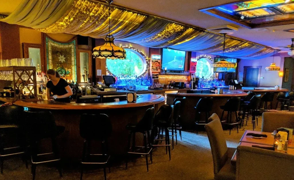 Elaborate bar and dining area with blue LED lighting and a bartender.