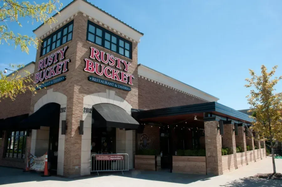 Rusty Bucket Restaurant and Tavern exterior with patio and banners.