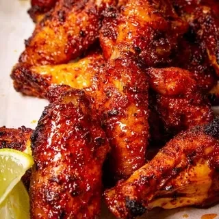 Glazed, reddish-brown chicken pieces with a lime wedge.