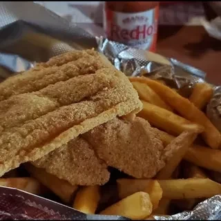 Two fried fish pieces and fries in a basket; RedHot sauce.