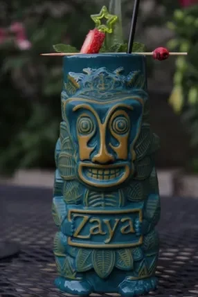 Sculpted teal Zaya tiki mug with a garnished dark drink.
