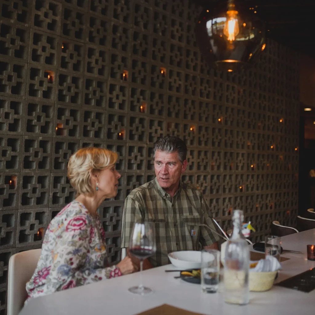 Woman and man seated at a table in a warm restaurant.