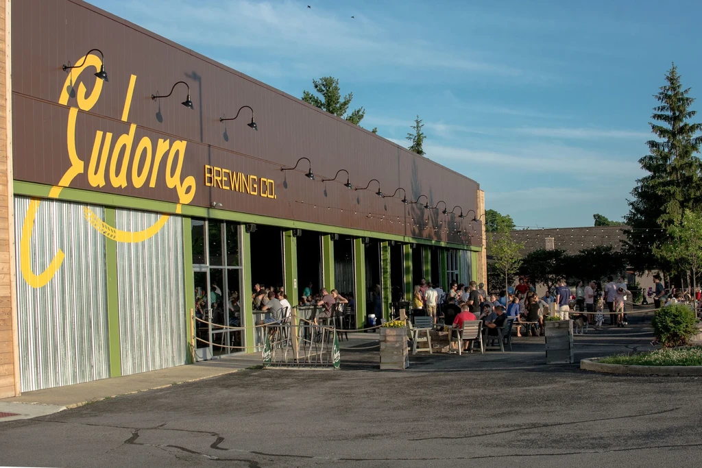 Eudora Brewing Co. building with a lively outdoor patio packed with people.