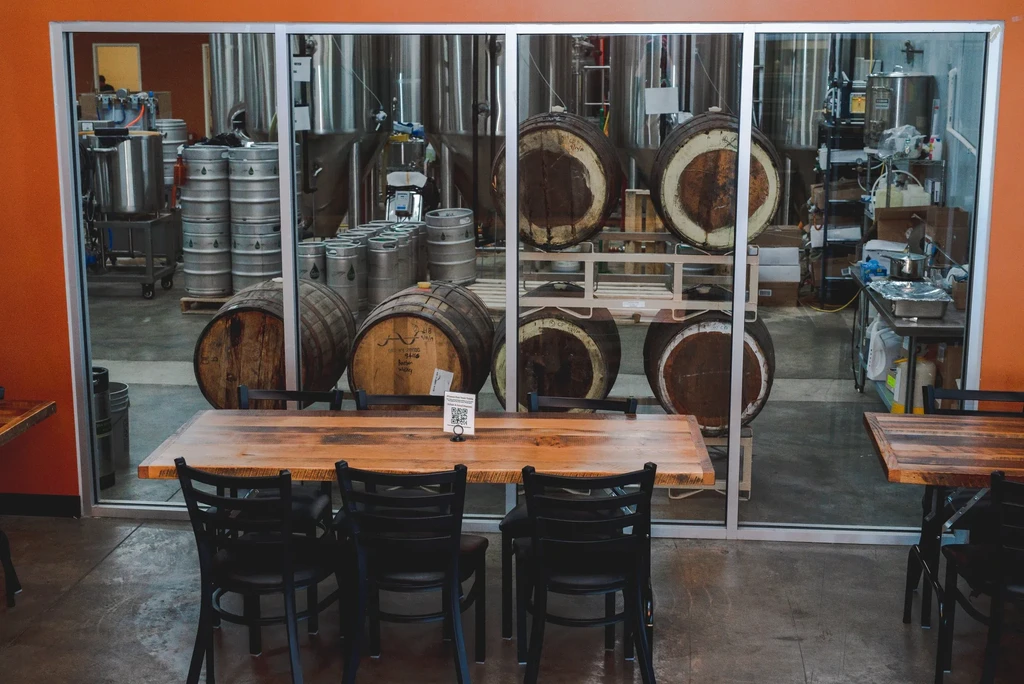 Brewery or distillery tasting room views tanks, kegs, and barrels.