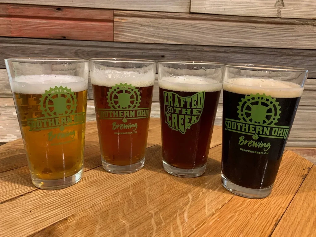Four Southern Ohio beers, light to dark, on wood.