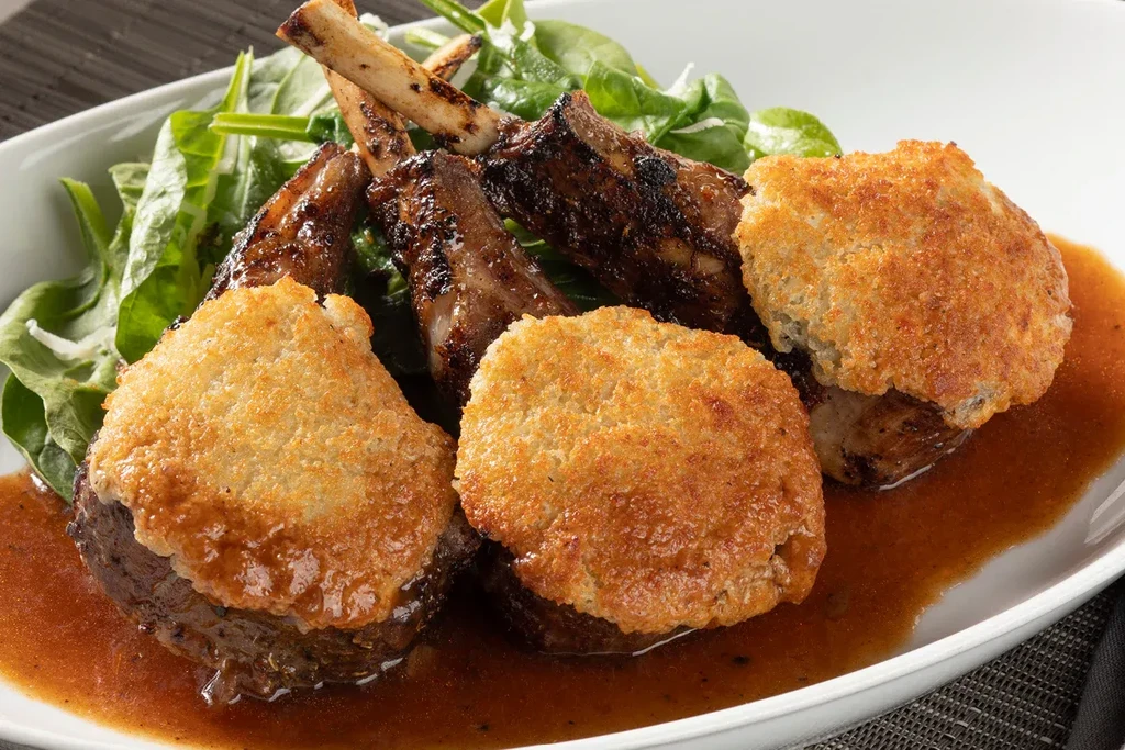 Grilled lamb chops, green vegetables, crispy patties, and sauce.