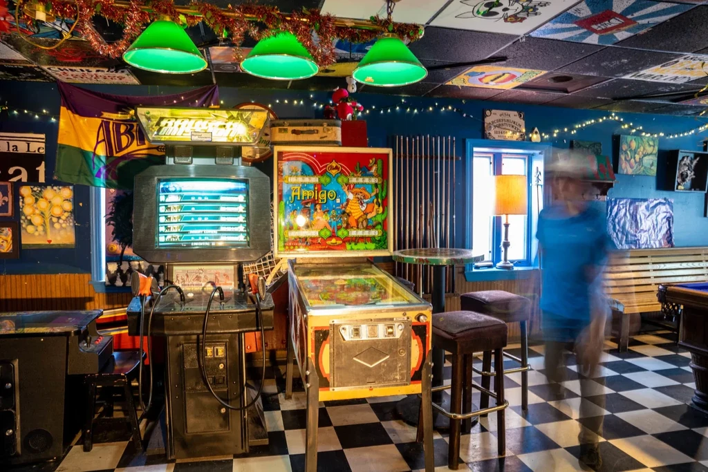 Lively arcade bar interior featuring pinball, video games, and unique decor.