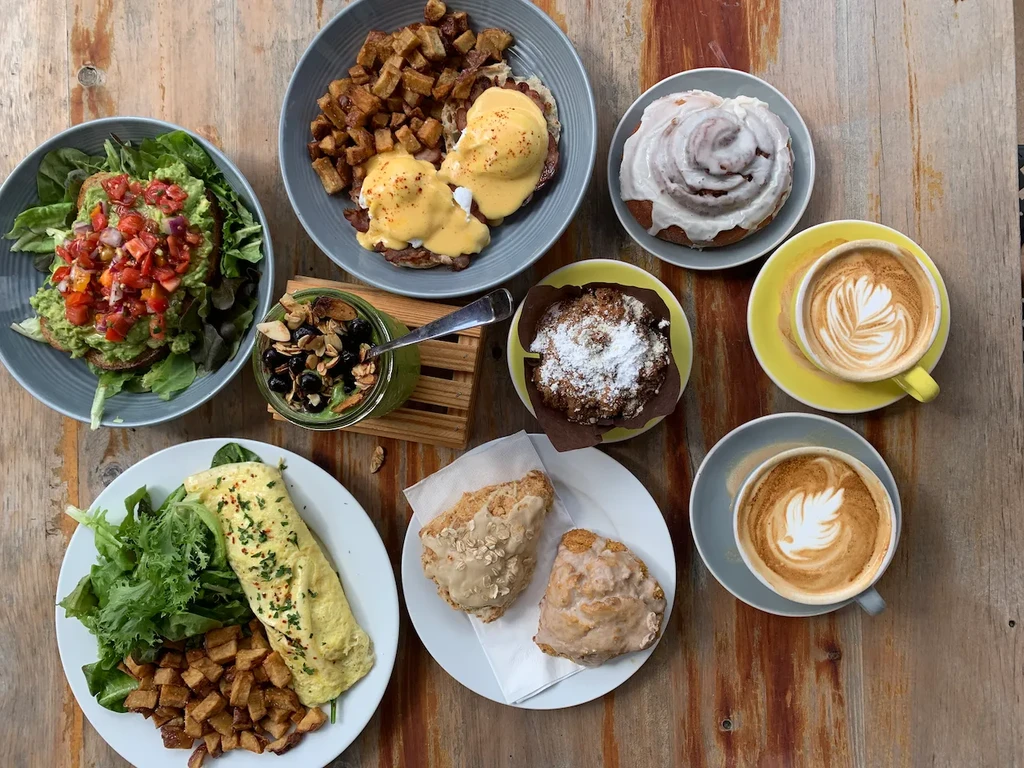 Flat-lay view of a large brunch spread on a rustic wooden table.