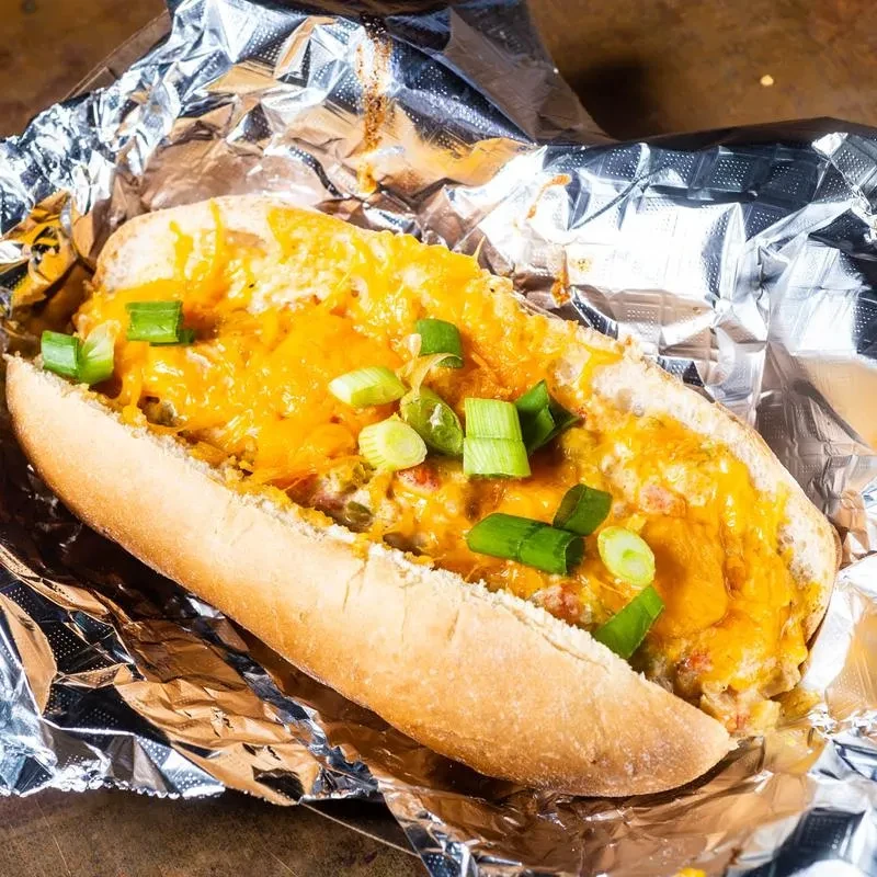Sub bun filled with creamy cheese, melted cheddar, and green onions.
