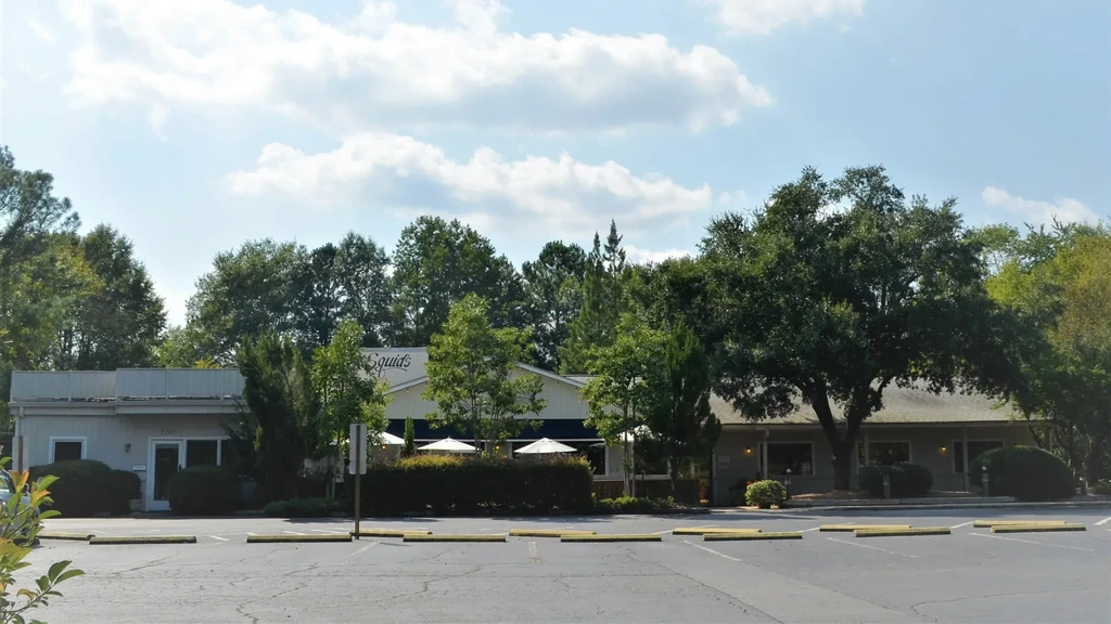 Exterior of Squid's restaurant with outdoor seating, empty parking lot.
