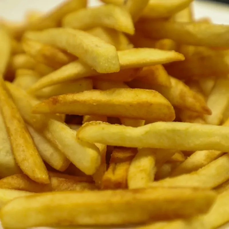 Pile of golden, cooked french fries with crispy edges.