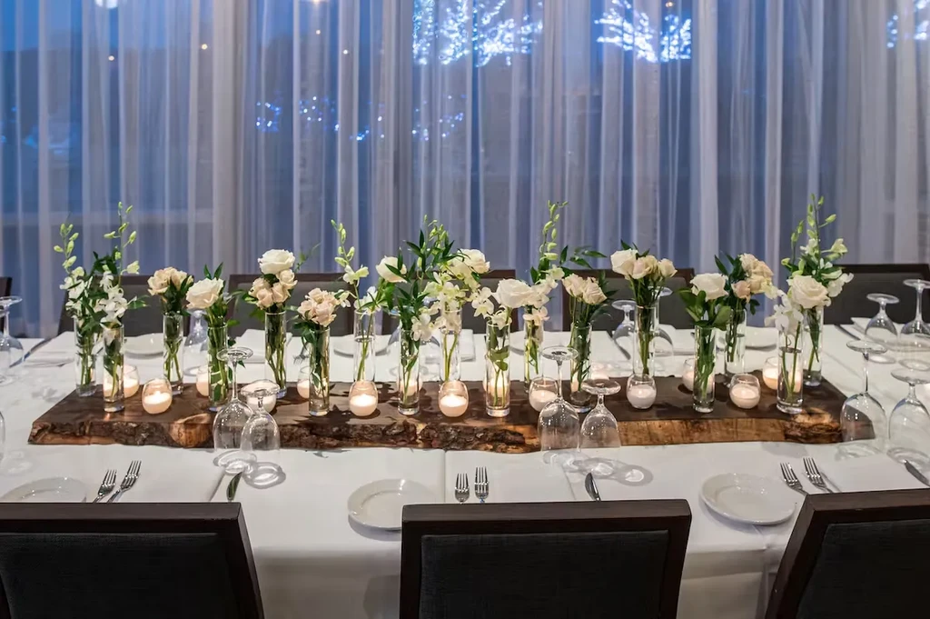 Elegant wedding reception table with floral centerpieces and candles.