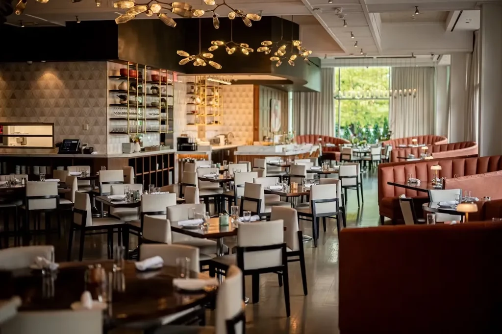 An empty modern restaurant with tables, chairs, and curved booths.