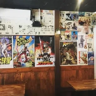 Walls decorated with vintage Japanese film posters and manga panels.