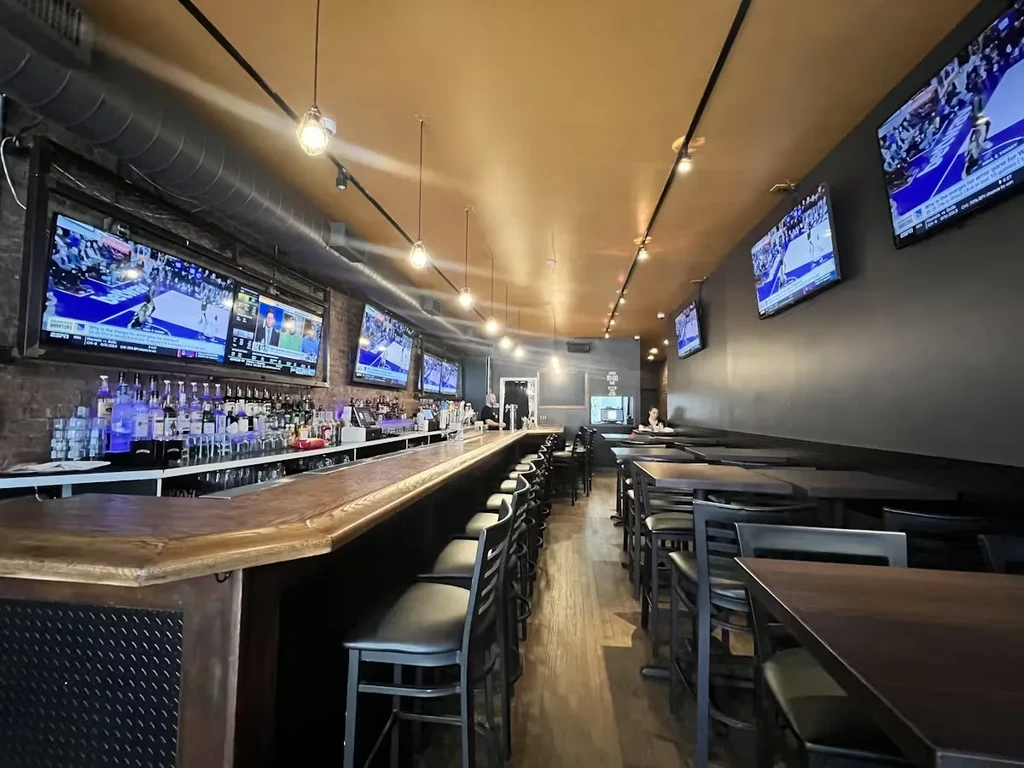 An empty bar and restaurant with TVs showing basketball games.