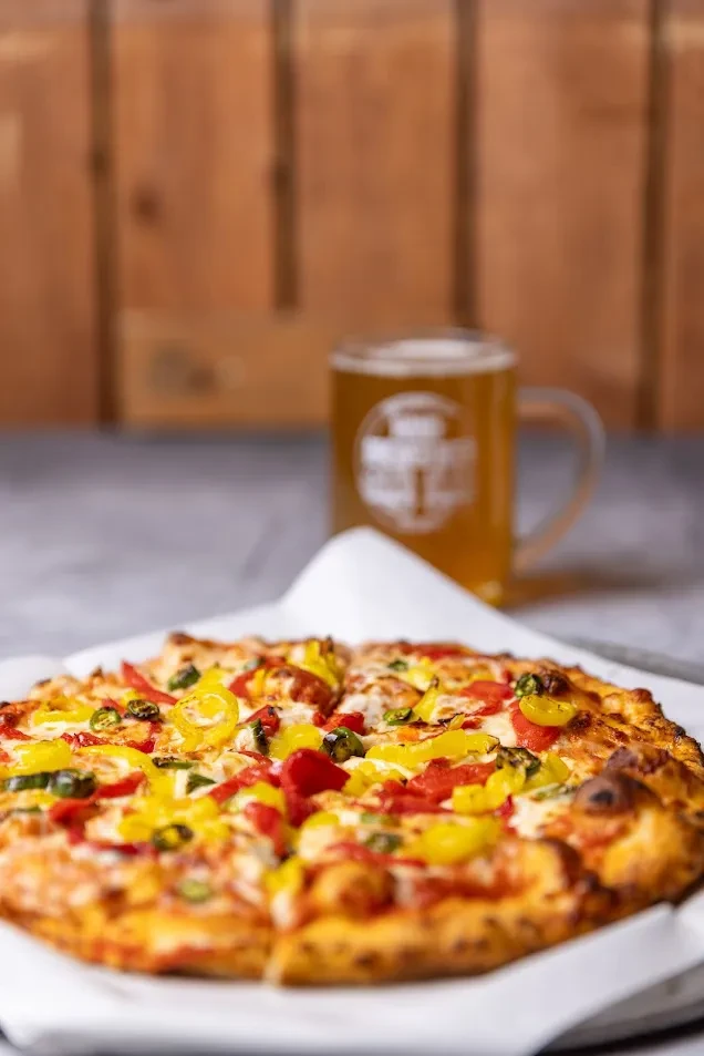 Sliced pizza with melted cheese, tomato sauce, banana and jalapeño peppers.