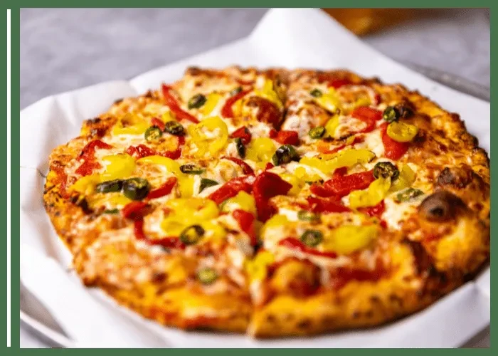 Pre-cut pizza with cheese, red bell, banana, and jalapeño peppers.