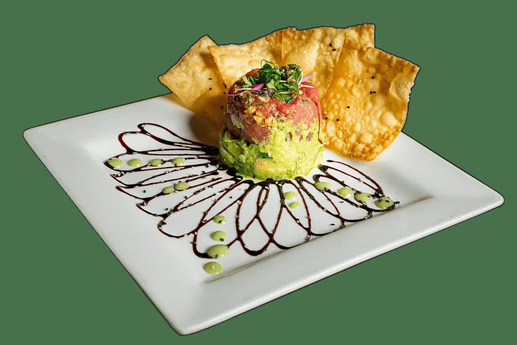 Artfully plated tuna tartare with avocado stack and chips.