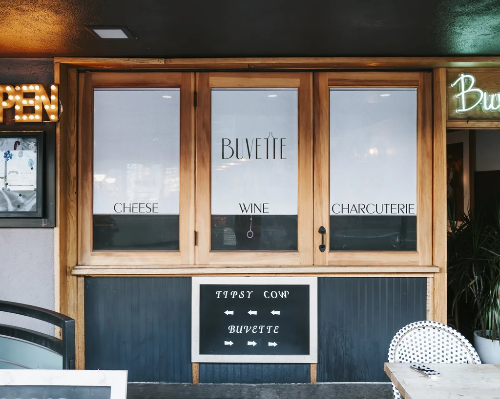 Front exterior of Buvette restaurant with 'Cheese', 'Wine', 'Charcuterie' signage.