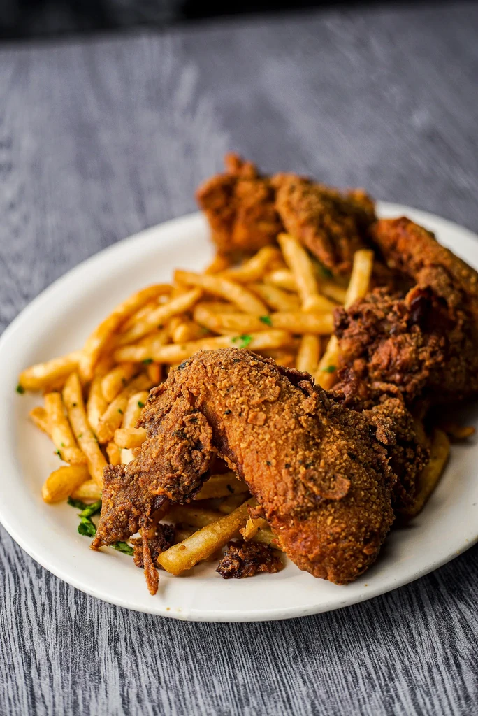 Crispy fried chicken and golden french fries garnished with herbs.