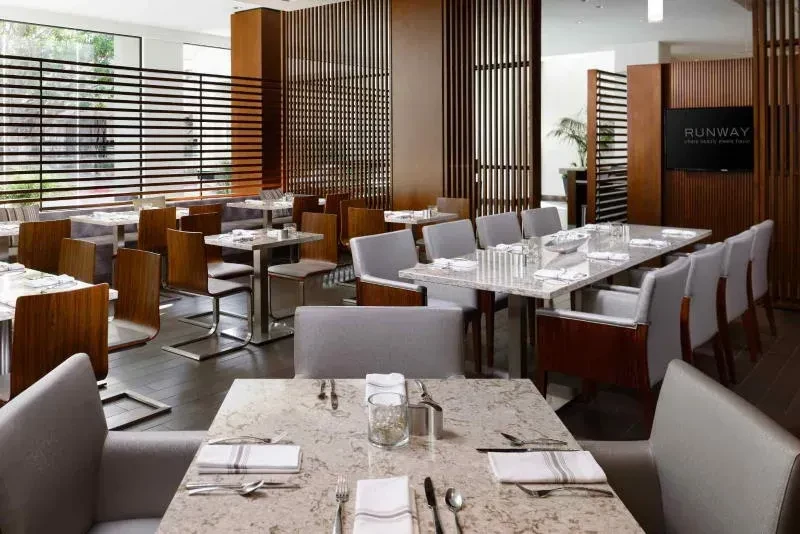Modern empty restaurant interior with varied tables and "RUNWAY" display.
