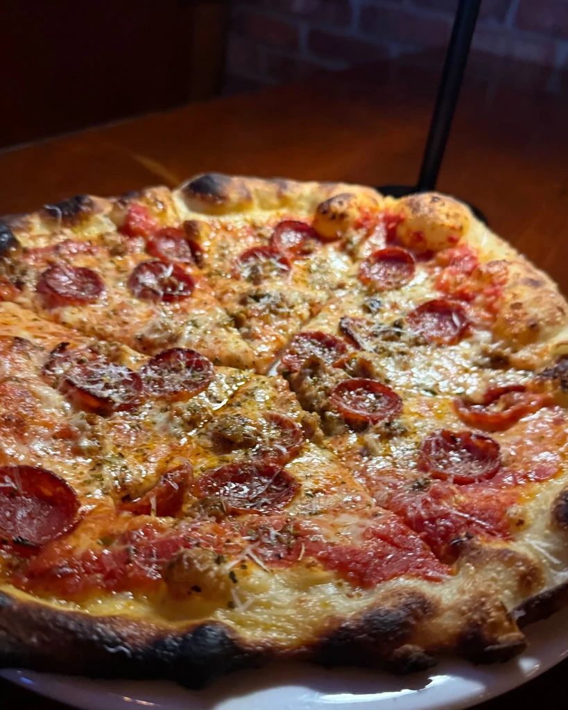 Close-up of a hot, freshly baked pepperoni and sausage pizza.