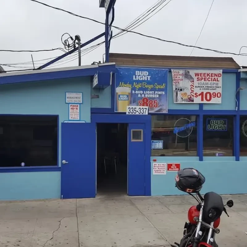 Light blue bar exterior with Fake ID sign and red motorcycle.