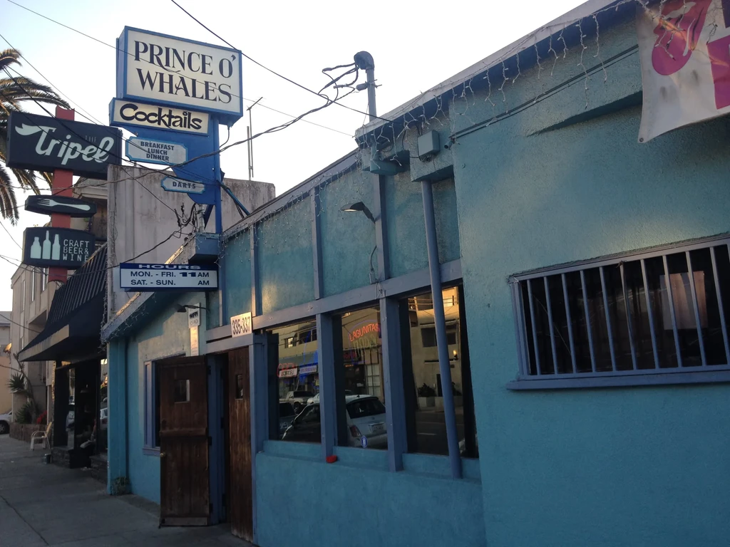 Teal building exterior with Prince O' Whales and The Tripel signs.