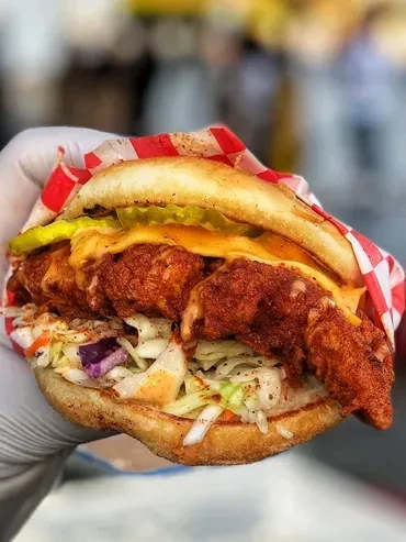Crispy fried chicken sandwich with melted cheese, pickles, and coleslaw.