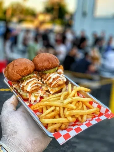 Two crispy chicken sandwiches and golden fries on a red checkered tray.
