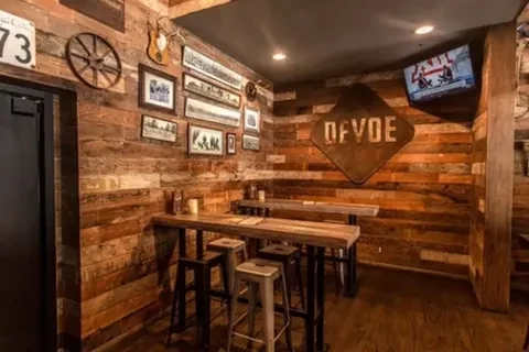 Rustic restaurant interior with reclaimed wood walls and eclectic decor.
