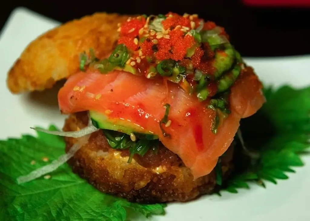 Layered sushi-style crispy rice patty with salmon, wakame, and tobiko.