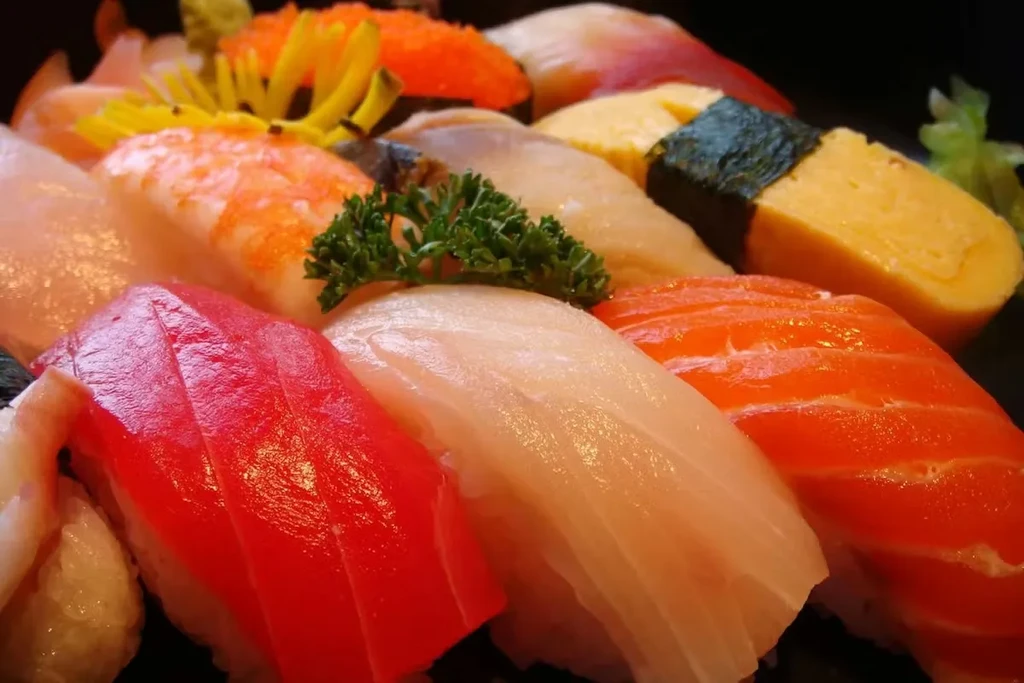 Vibrant, fresh sushi and nigiri assortment on a dark platter.
