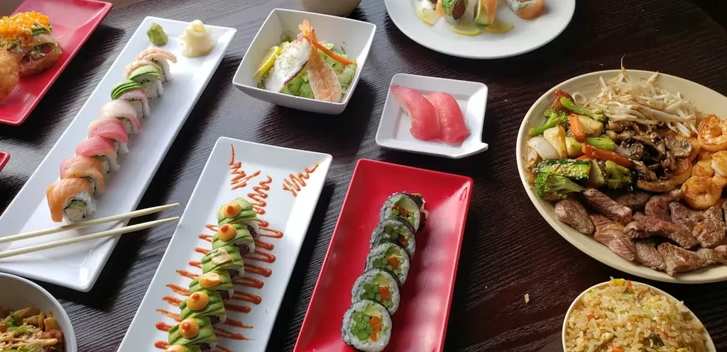 Overhead view of diverse Japanese sushi, stir-fry, and other dishes.