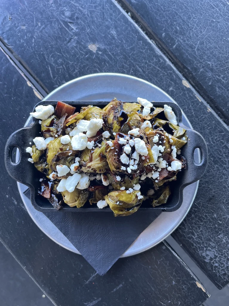 Skillet of caramelized Brussels sprouts with bacon, feta, and balsamic glaze.