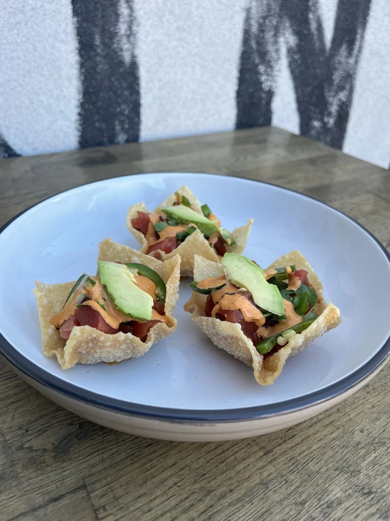 Three crispy wonton cups filled with poke, avocado, and sauce.