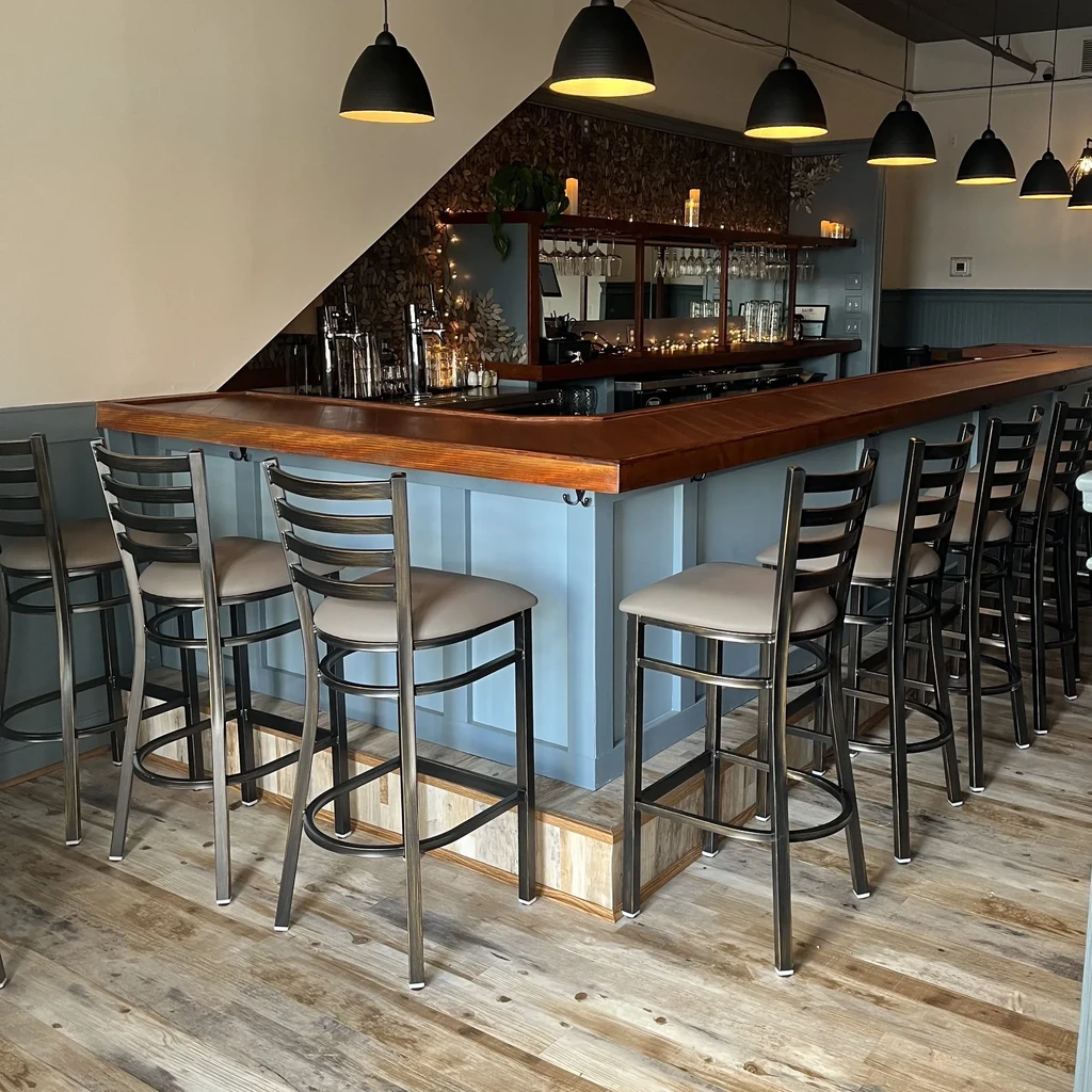 Well-lit bar with blue-grey panels, dark wood, and patterned wall.